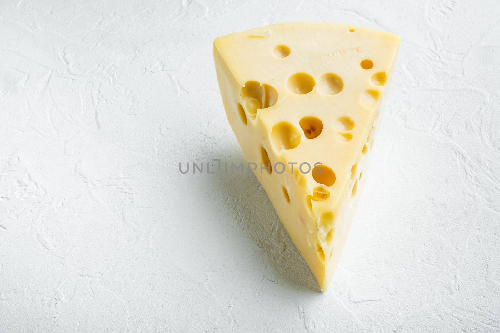 Maasdam cheese set, on white stone surface, with copy space for text