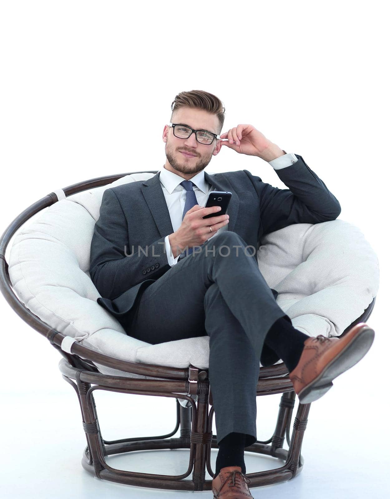 close up.successful businessman with smartphone sitting in a soft chair.isolated on white