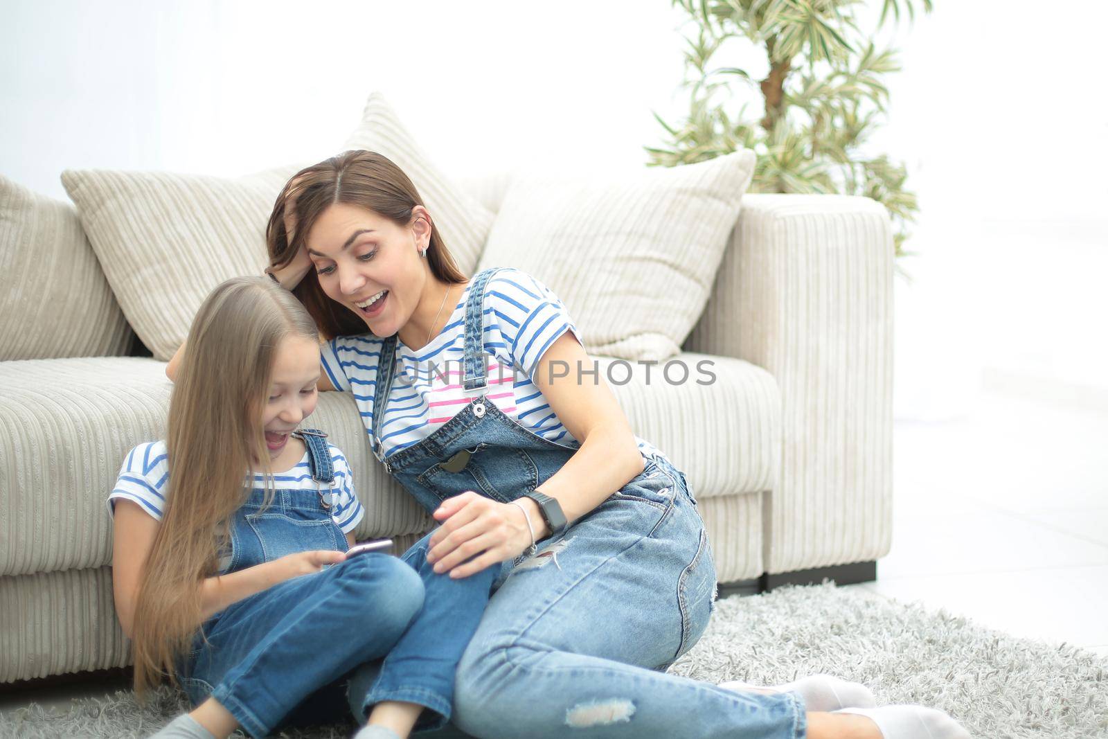 mother and her little daughter use a smartphone to view the photo.photo with copy space