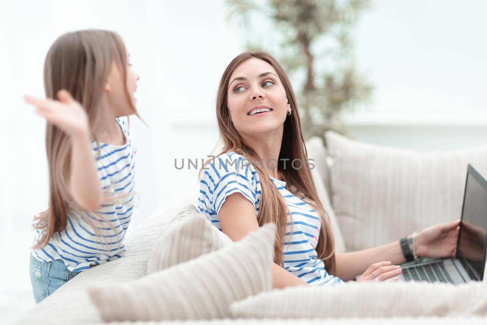 mom and daughter sitting on the couch in the living room.happy together