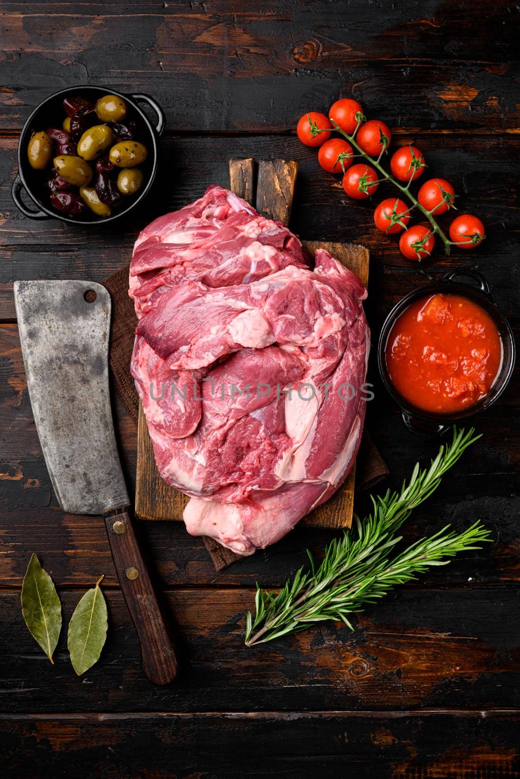 Fresh and raw meat Lamb or mutton set, with ingredients and herbs, on old dark wooden table background, top view flat lay