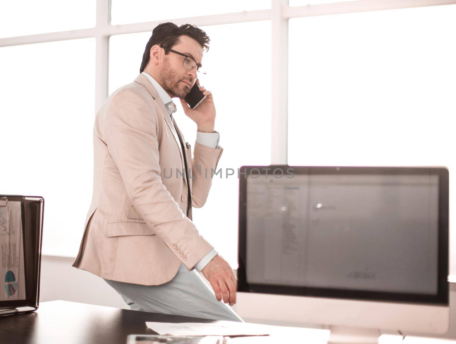 serious businessman talking on smartphone sitting on his desktop.business concept