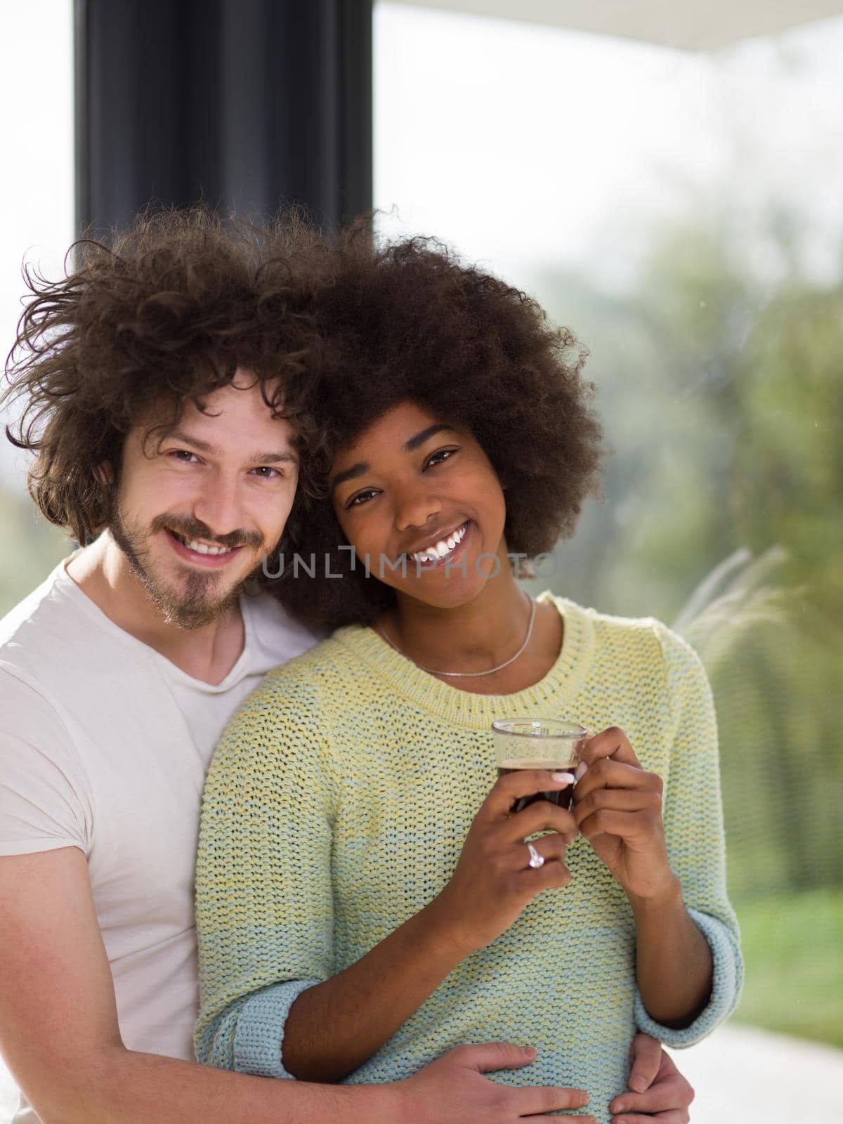 romantic happy young multiethnic couple enjoying morning coffee by the window in their luxury home