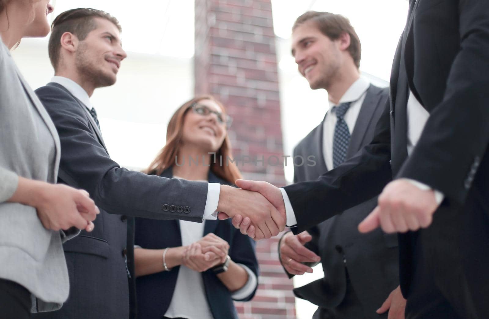 Happy businesswomen shaking hands in office