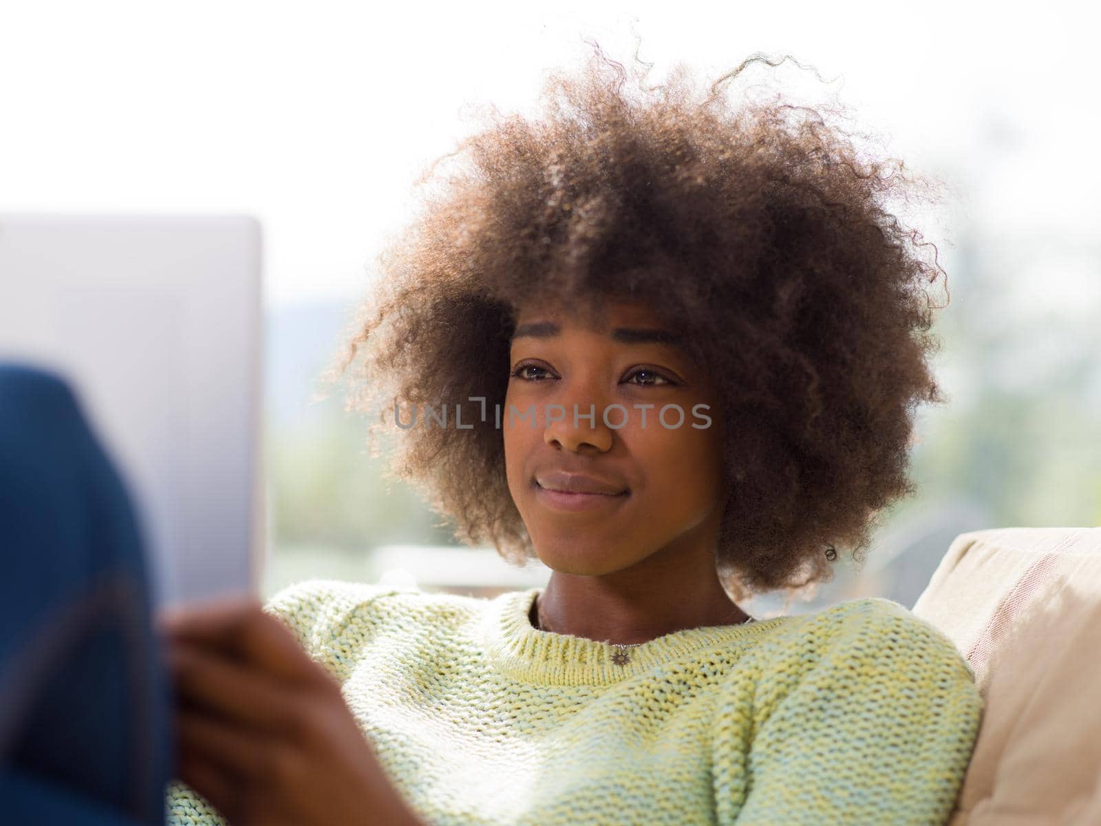 Young african american woman at home relaxing in her luxury lliving room reading a digital tablet  surf internet and work