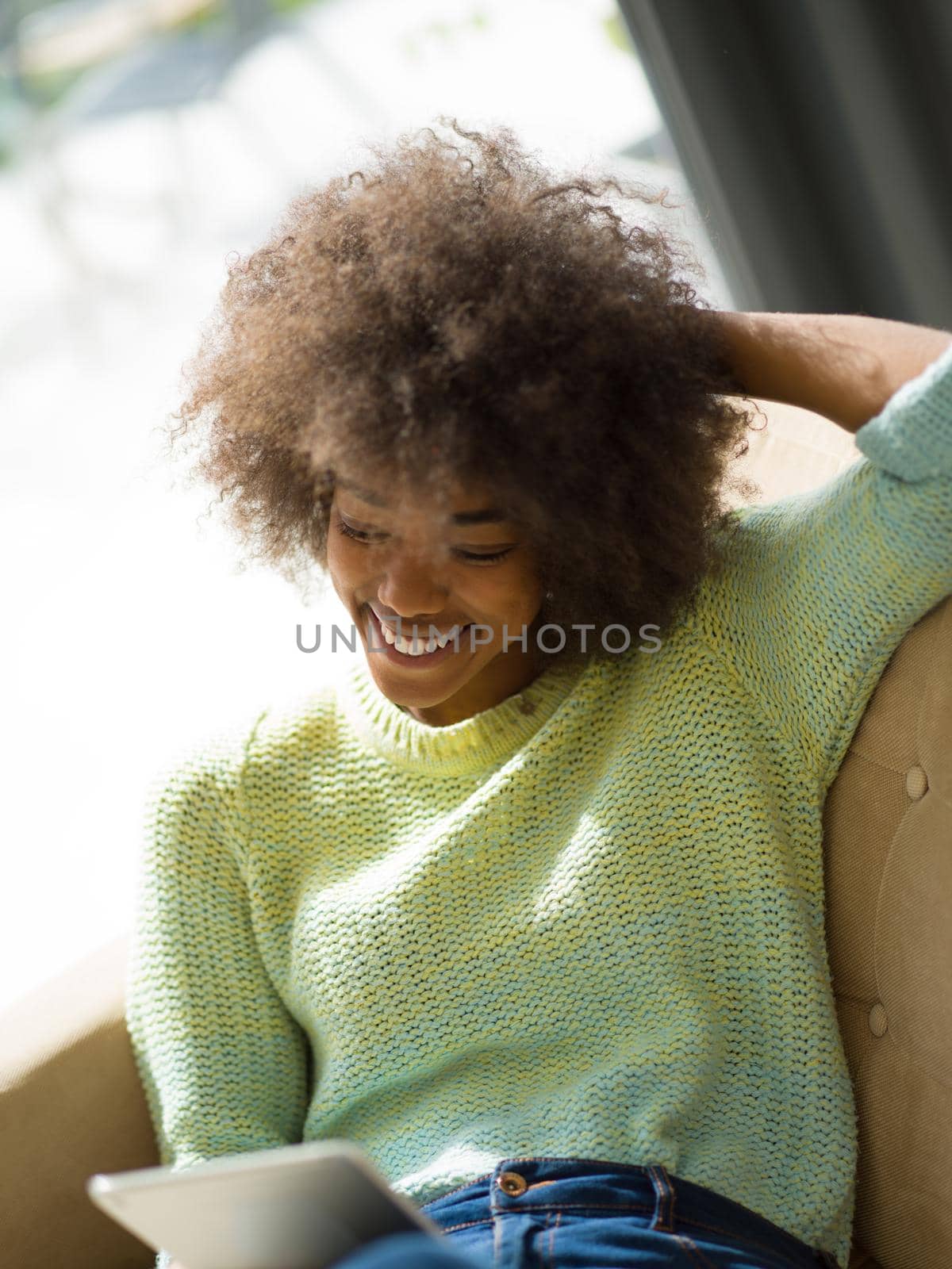 Young african american woman at home relaxing in her luxury lliving room reading a digital tablet  surf internet and work