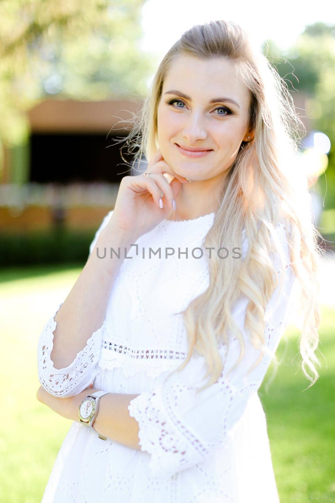 Portrait of young smiling blonde woman wearing white clothes. Concept of beauty and female person.