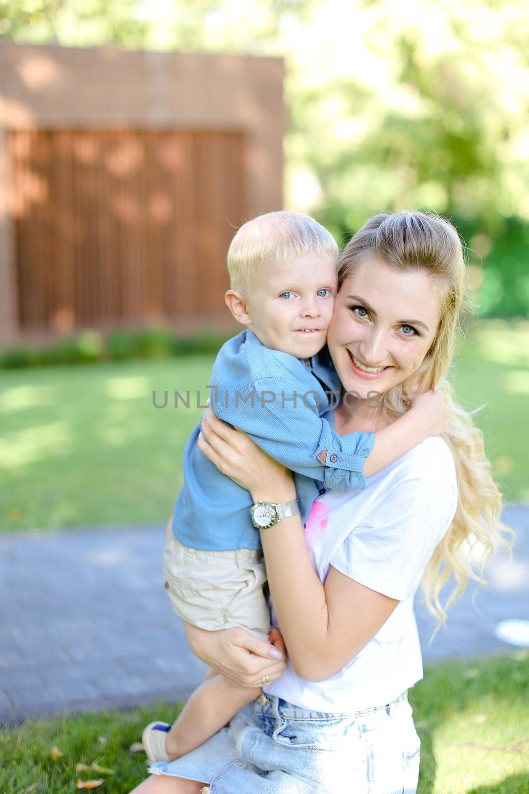 Young smiling mother hugging little son. by sisterspro