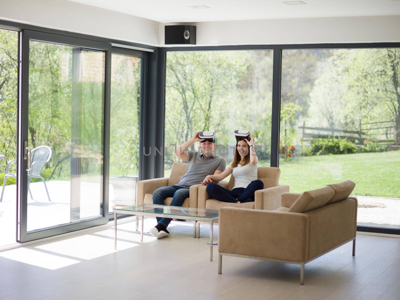 Couple using virtual reality headset in living room at home  people playing game with new trends technology