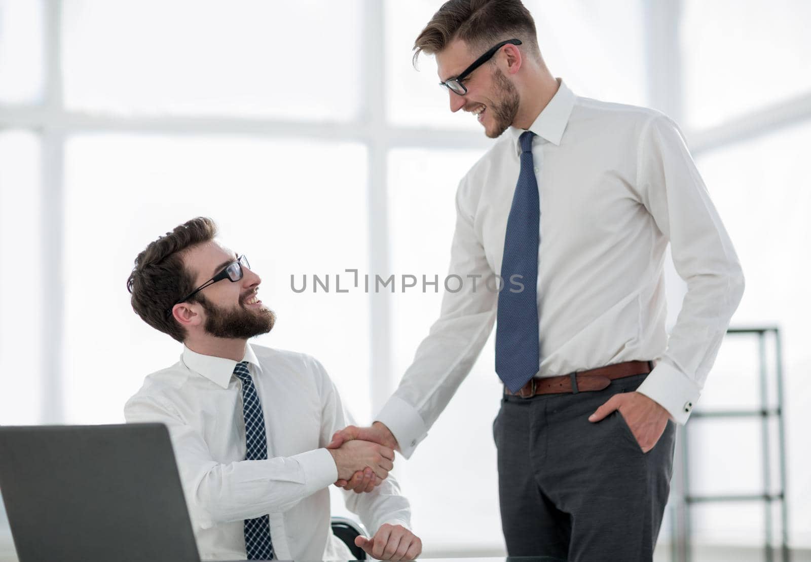 handshake employees in the workplace in the office .business concept