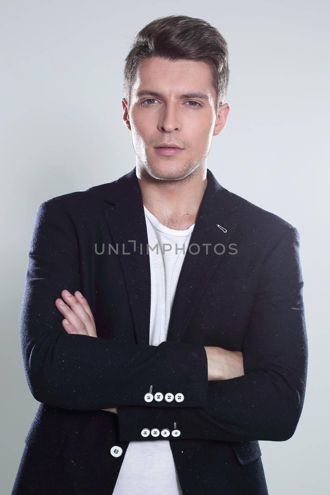 Happy smiling man with crossed arms pose, with blank copyspace area for text or slogan, against grey background