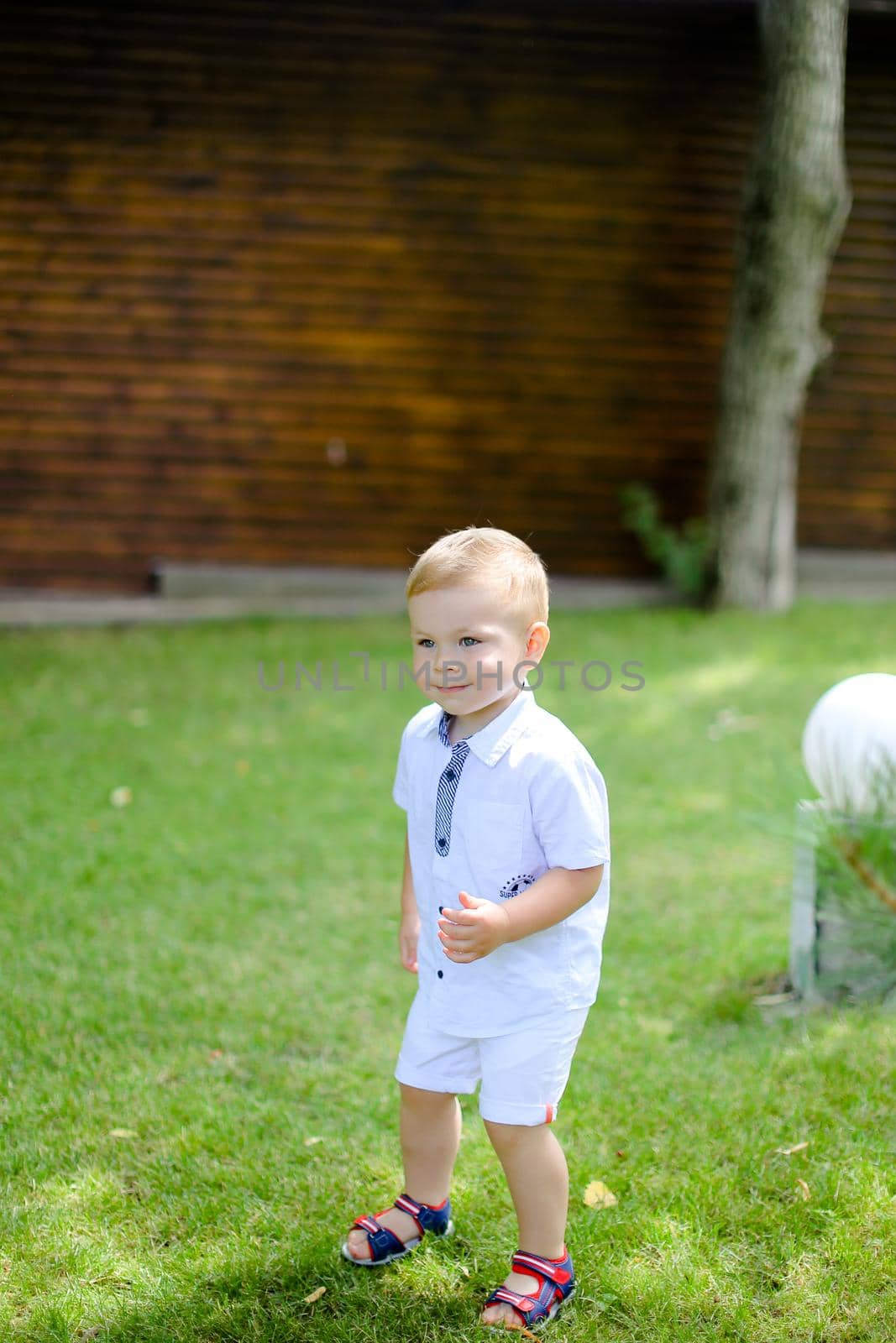 Little baby standing on grass. Concept of childhood and summer.