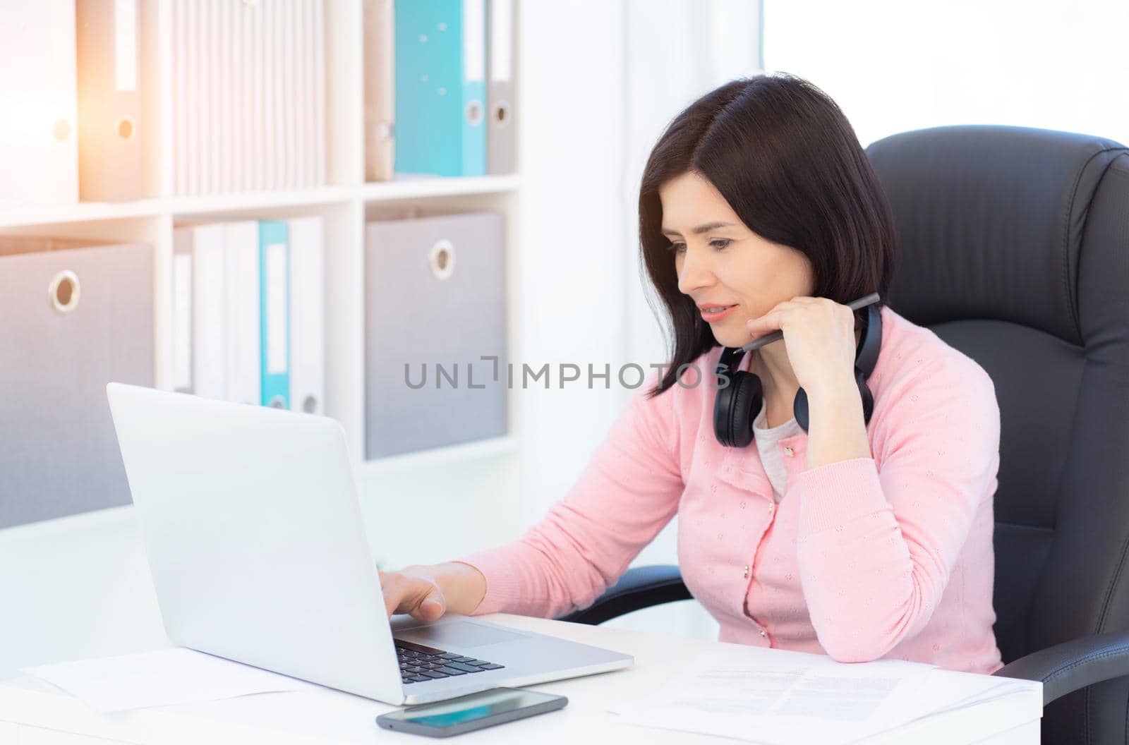 Pretty woman working on laptop in modern office