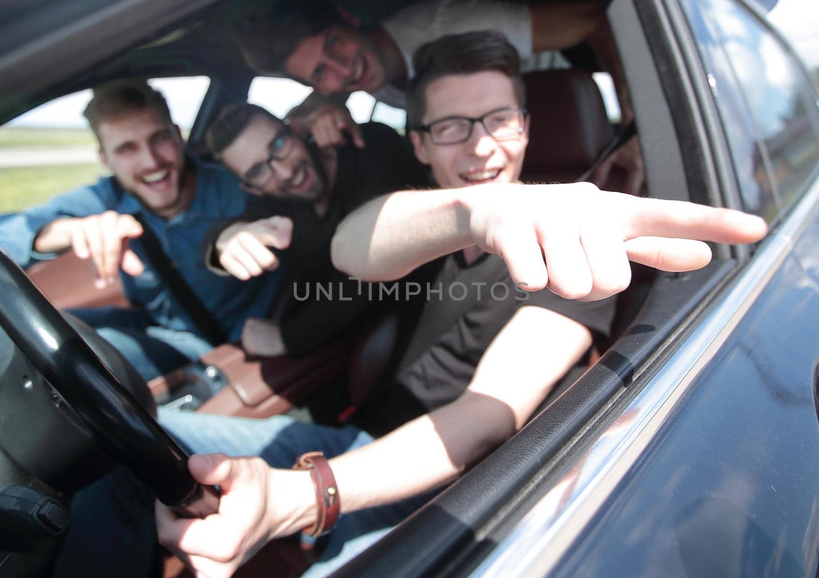 side view . friends sitting in the car and looking at the camera.joint trip