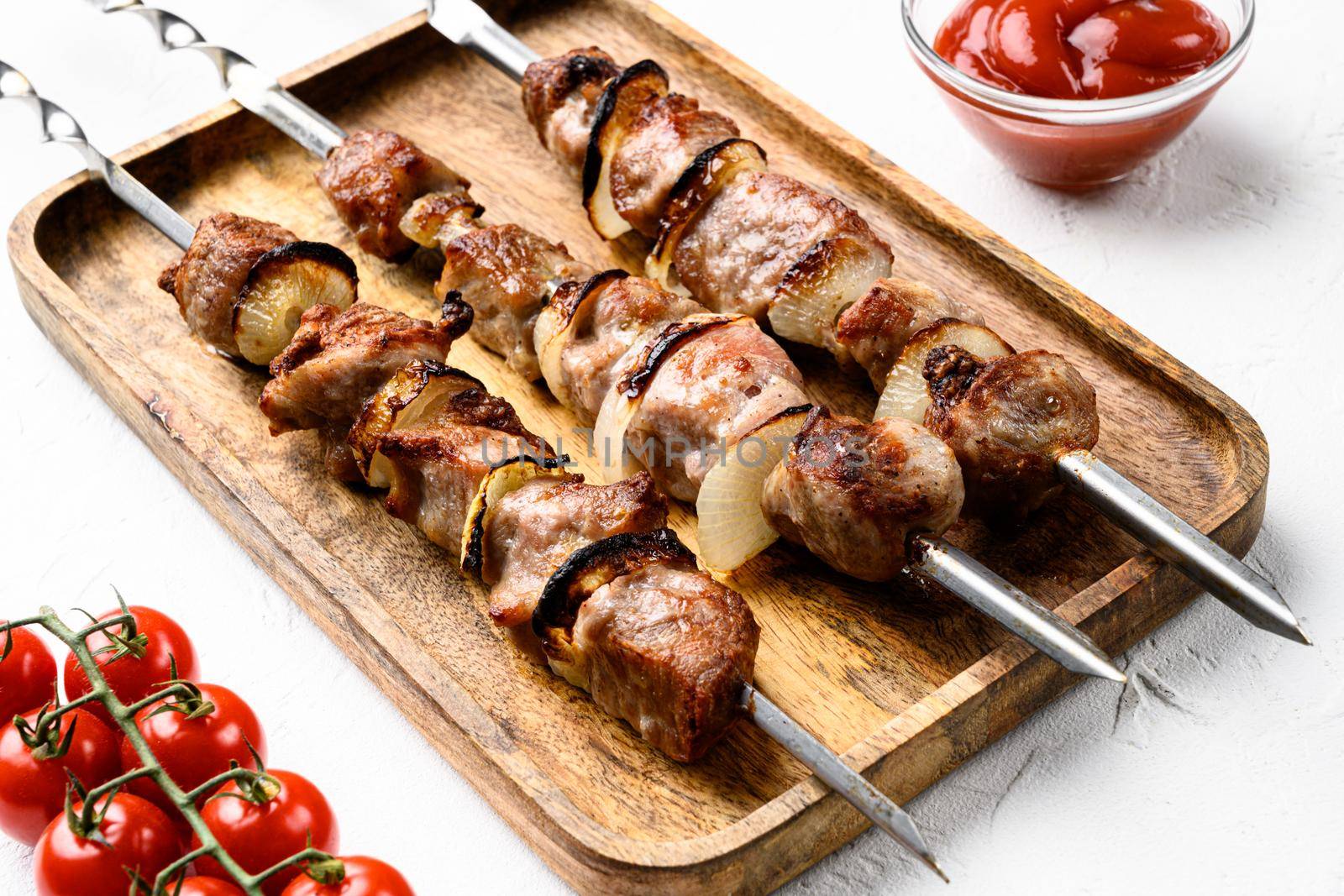 Shish kebab BBQ meat with onions and tomatoes set, on white stone table background