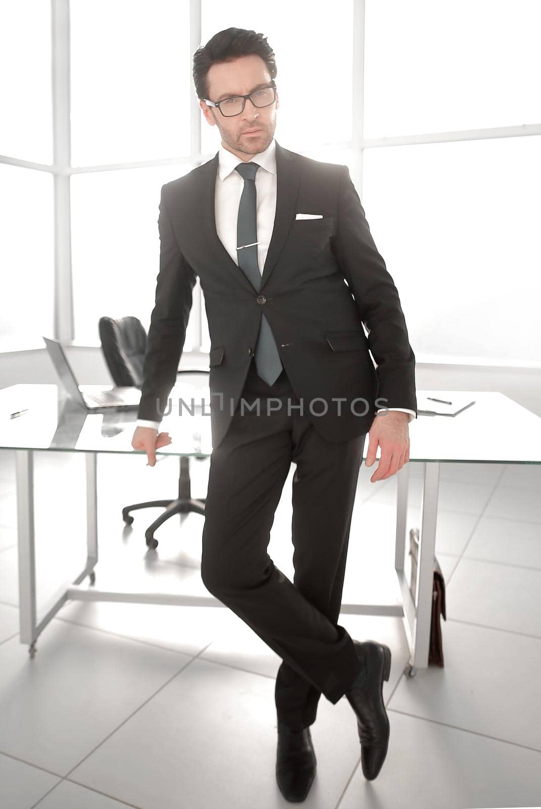 Confident in the future. successful businessman standing near his Desk.