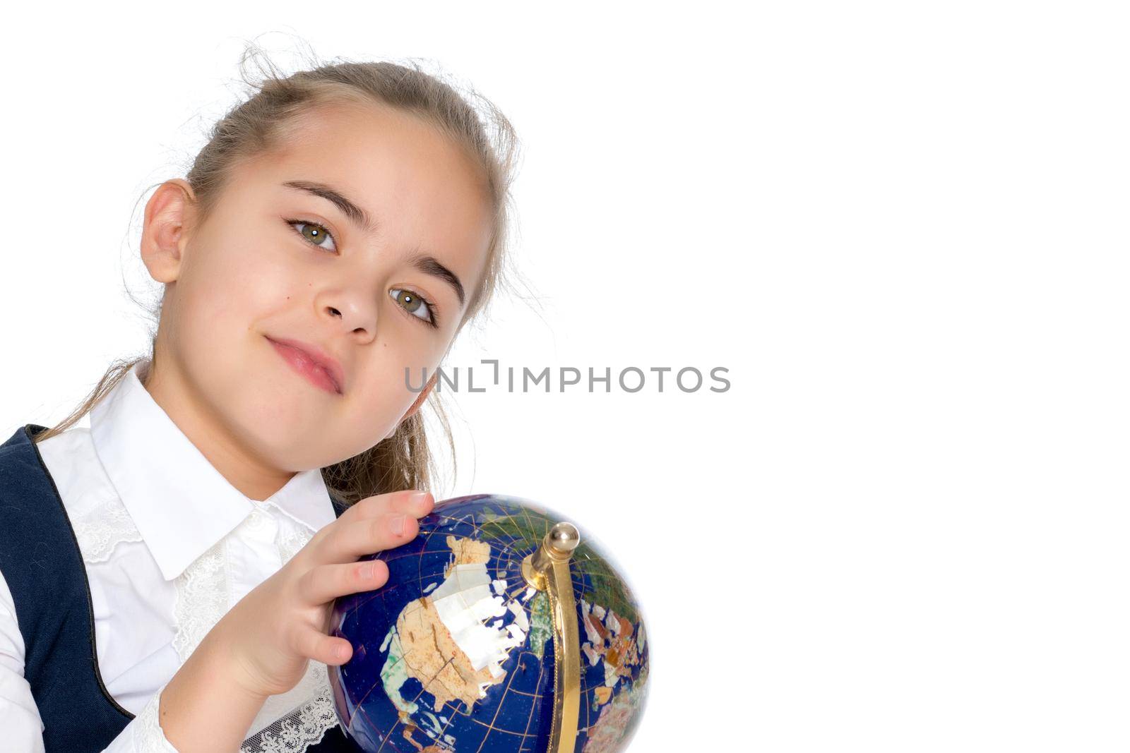 Beautiful little schoolgirl girl studying a globe on a white background. The concept of teaching geography in school, travel. Isolated.