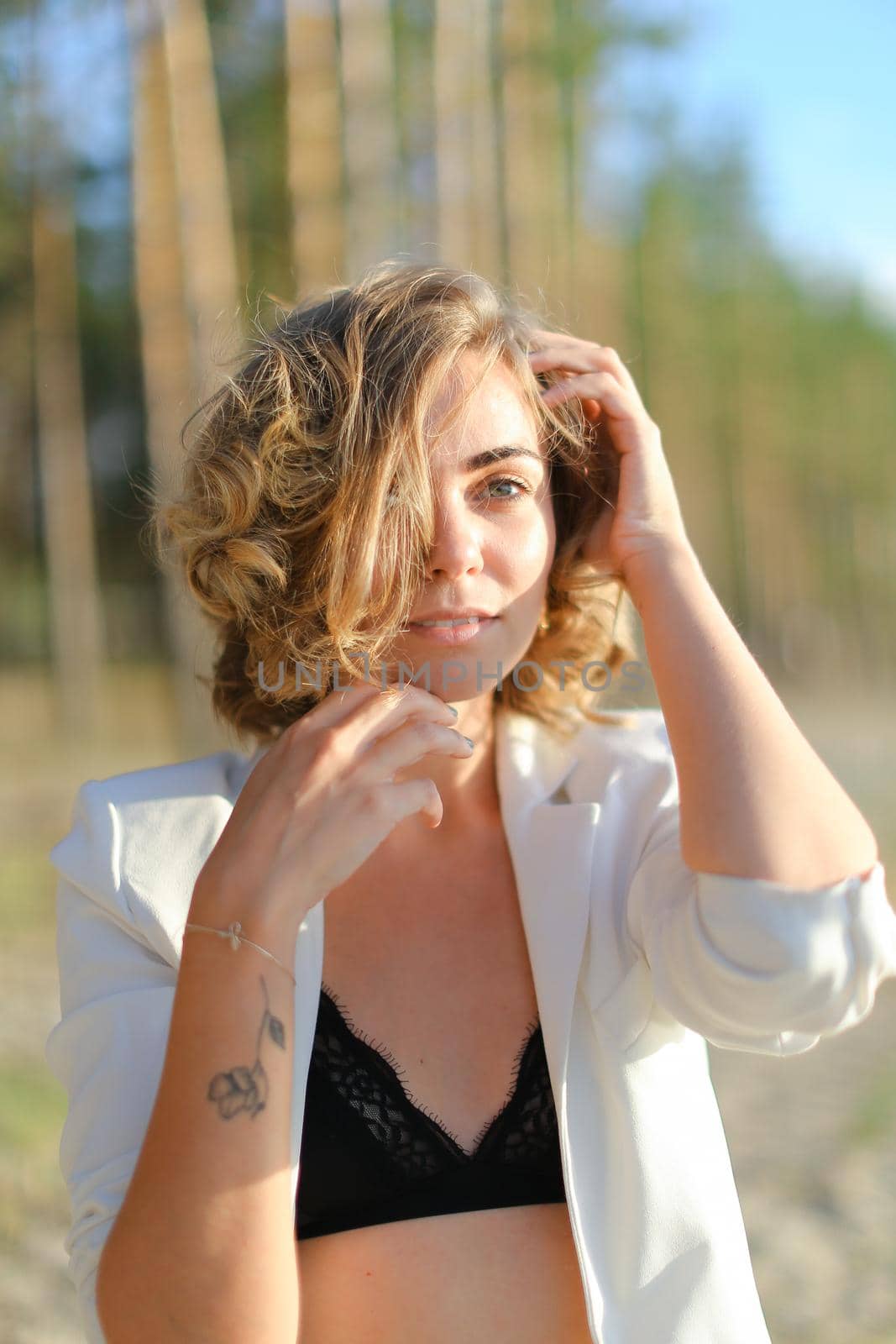 Caucasian girl with tattoo walking on sand beach and wearing white shirt. by sisterspro