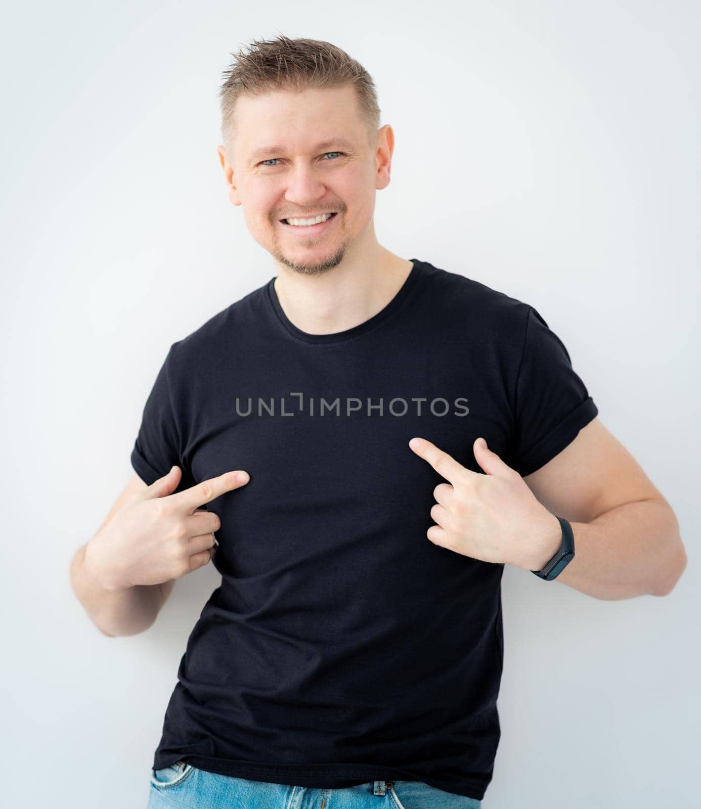 Attractive man pointing at blank black t-shirt
