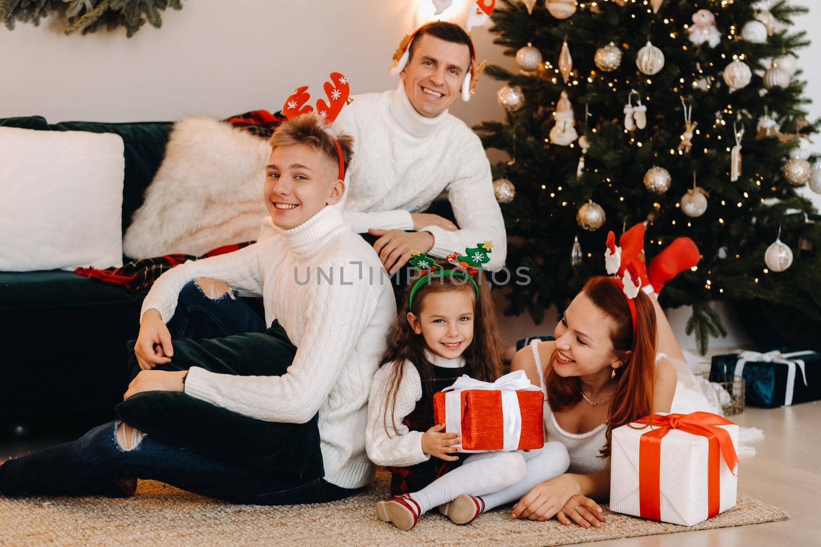 Happy family near the Christmas tree with gifts.