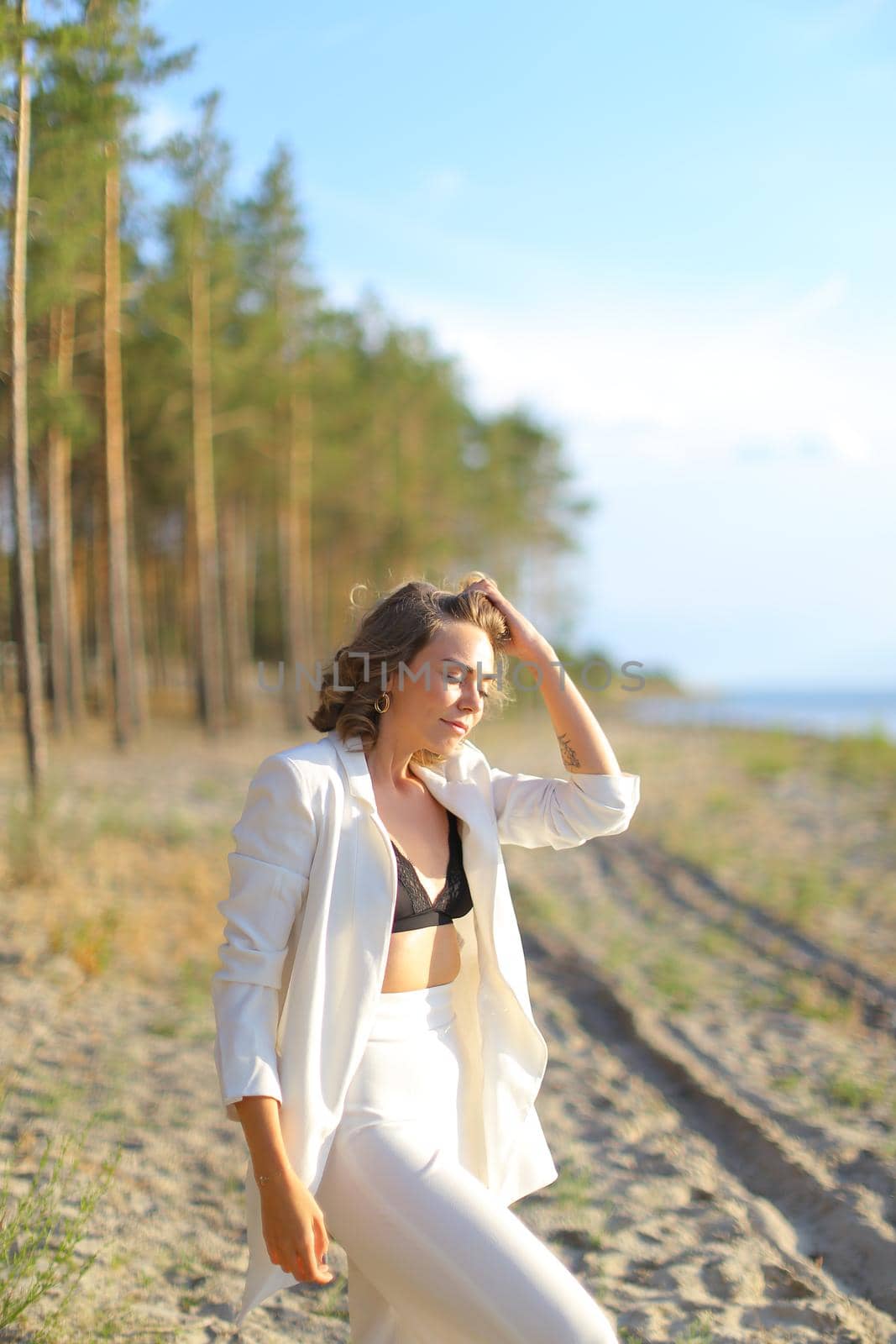 Pretty caucasian girl walking on sand beach and wearing white clothes. by sisterspro