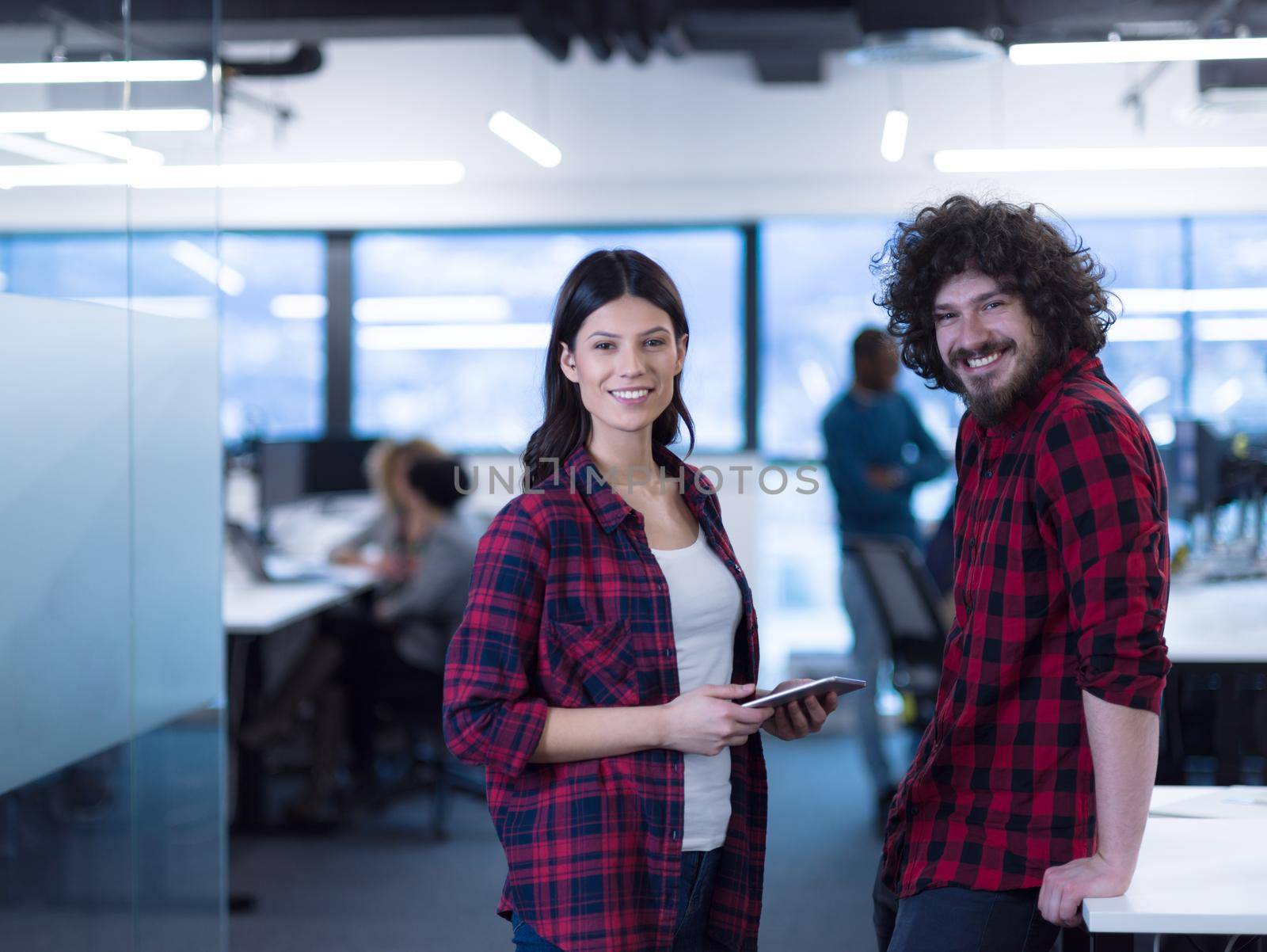 portrait of successful business couple software developers at busy startup office