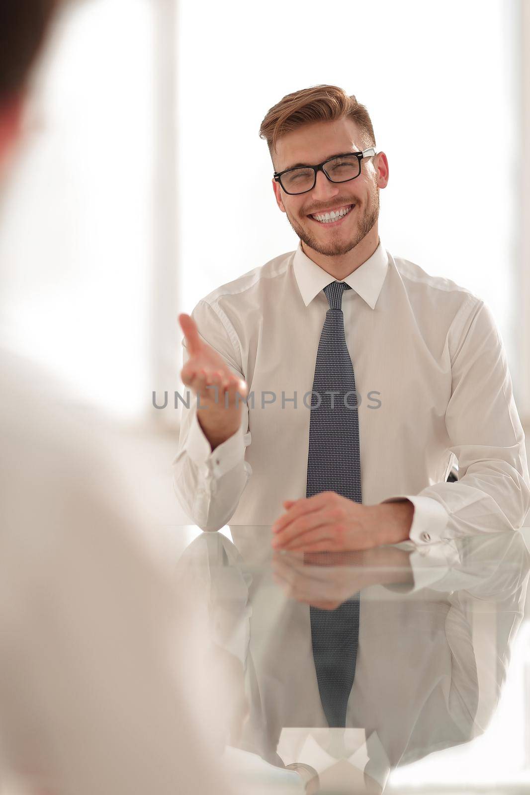 confident businessman sitting at the office table by asdf