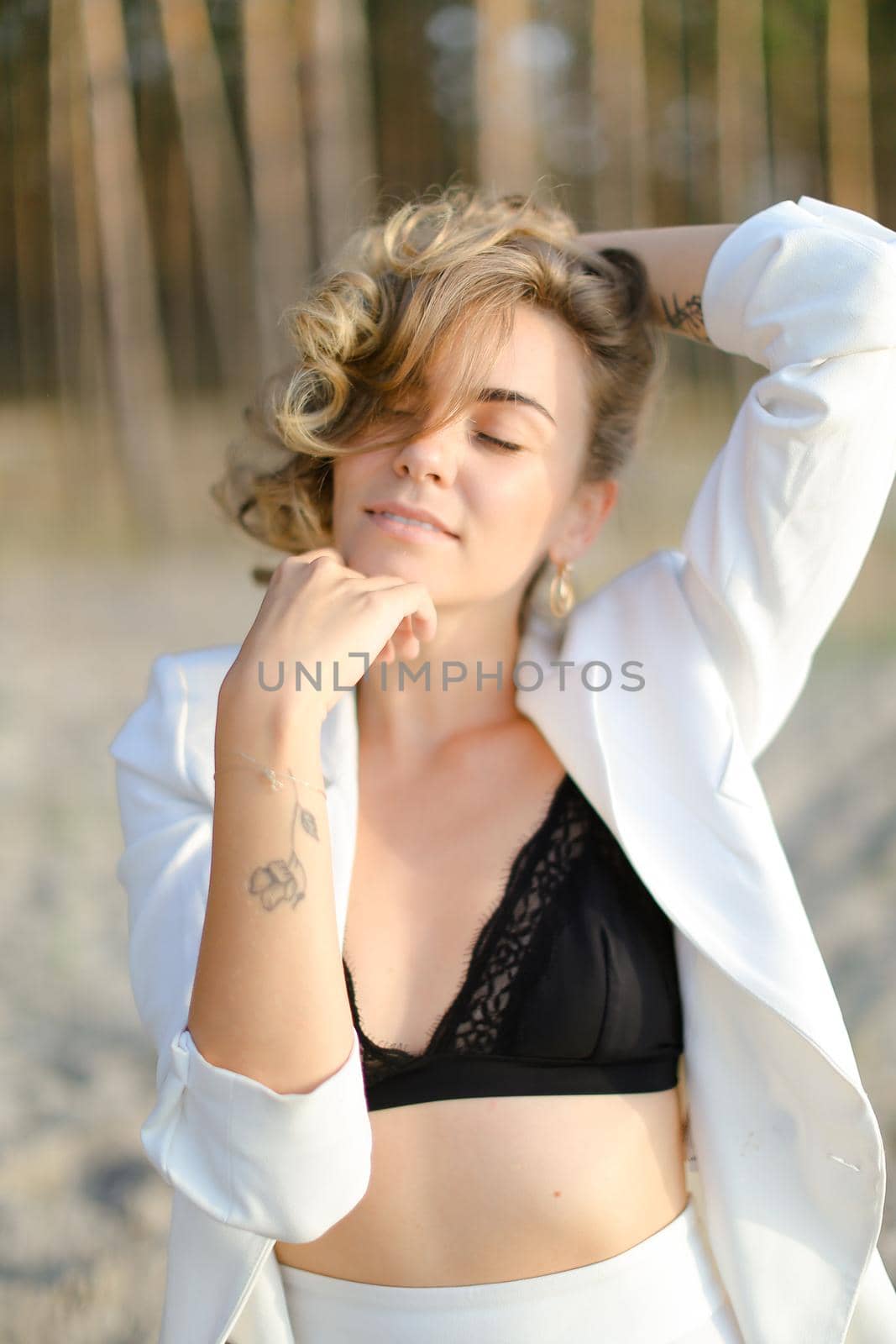 Portraint of young fashionable girl with little hand tattoo wearing white shirt and black bra. Concept of beauty.