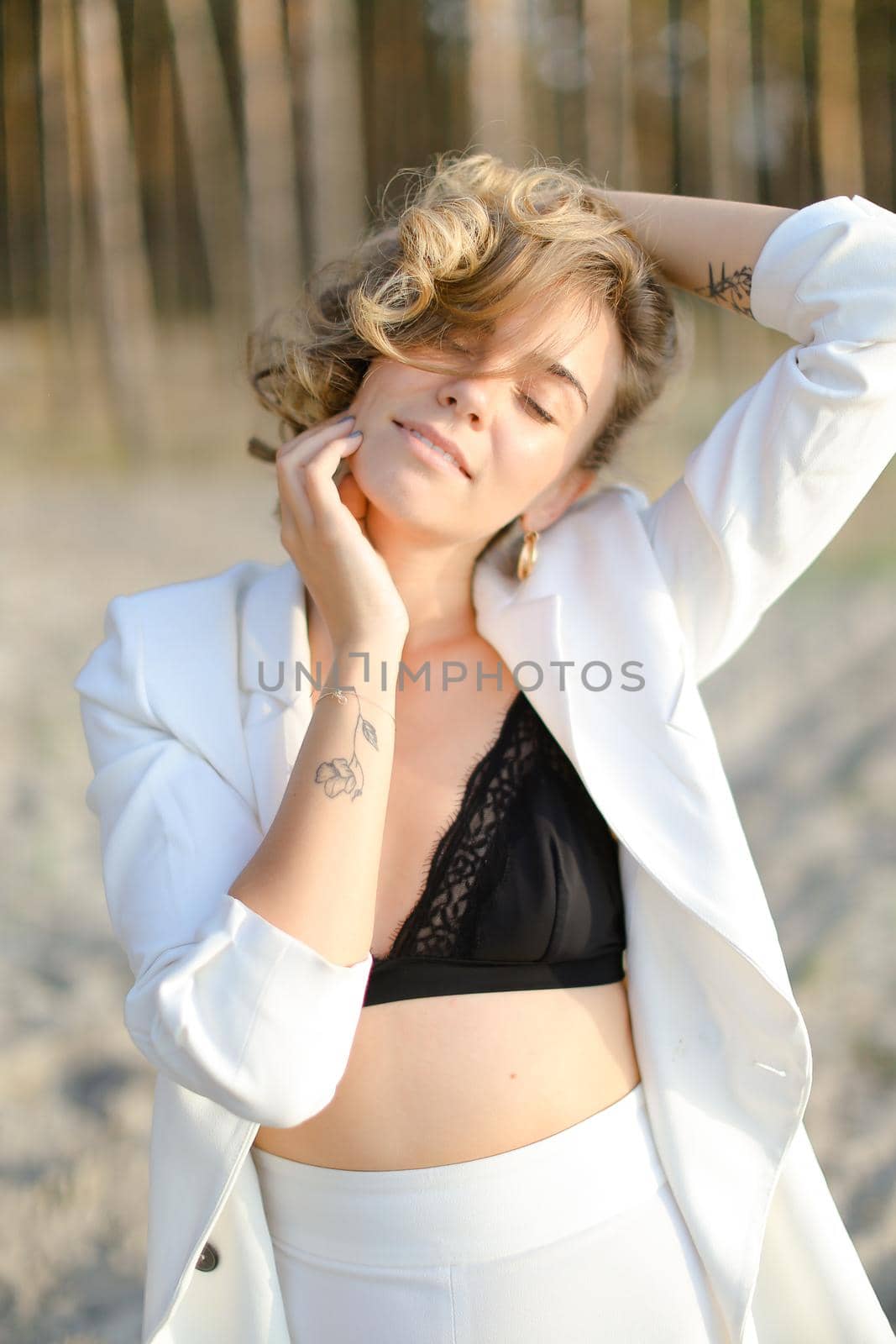 Portraint of young relaxed man with little hand tattoo wearing white shirt and black bra. by sisterspro