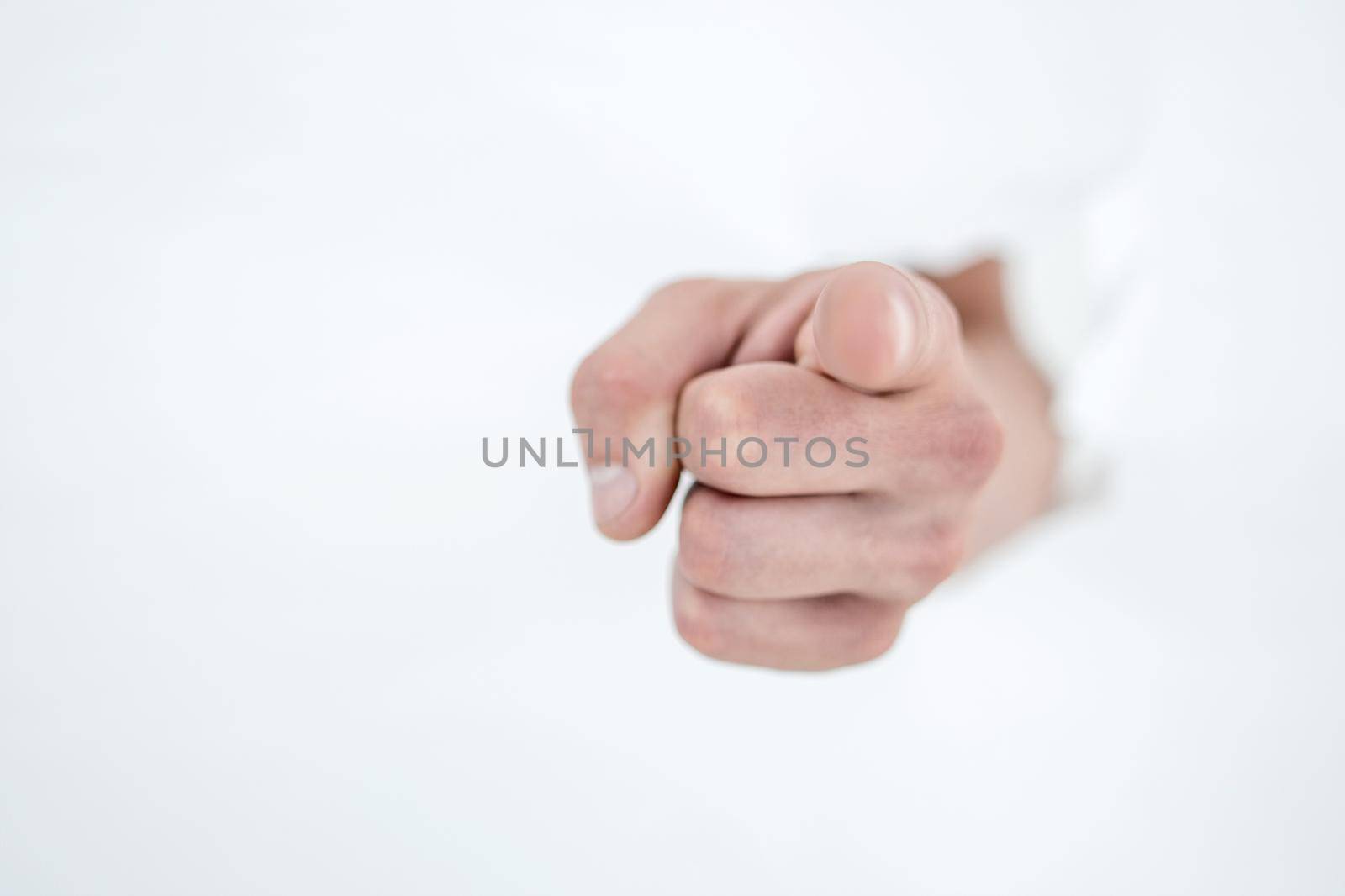 man's hand breaking through the paper wall and pointing at you .photo with copy space