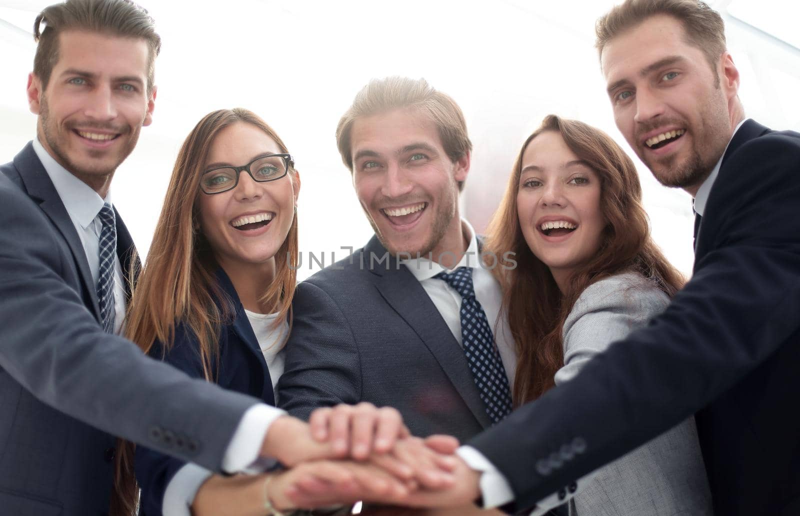 Creative team putting their hands together in circle