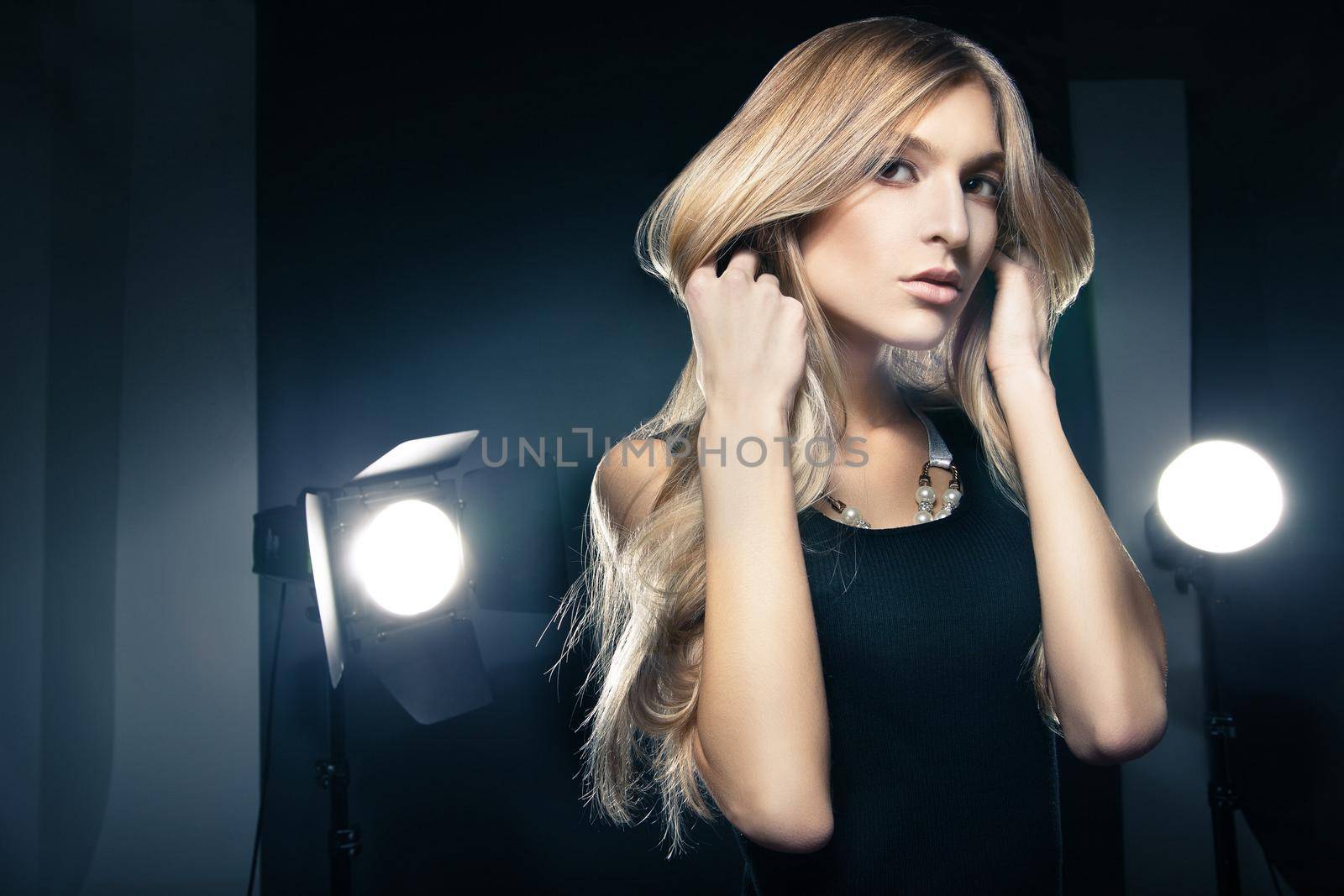 Beautiful woman posing at studio in light flashes by Julenochek