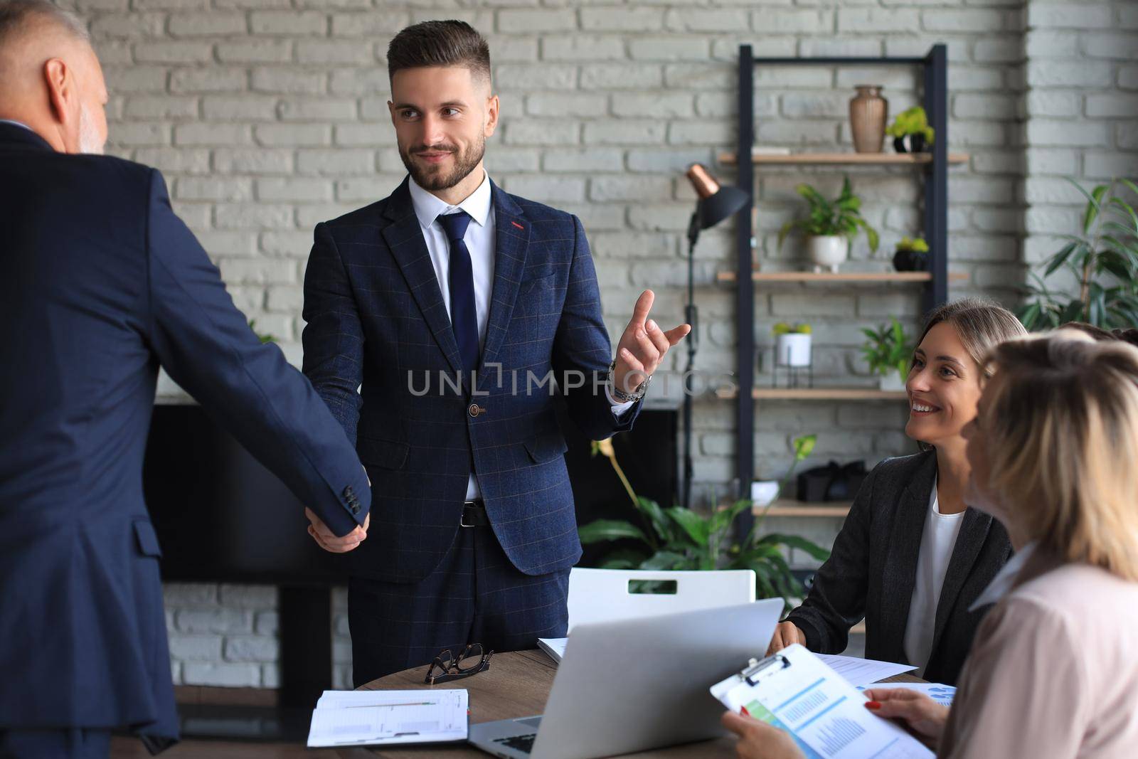 Business people shaking hands, finishing up a meeting. by tsyhun