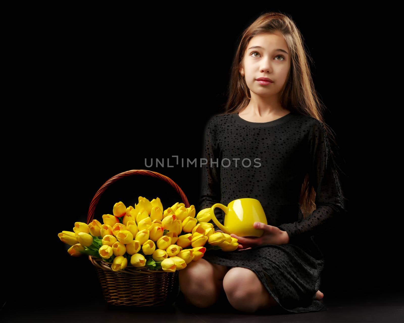 Little girl with a bouquet of tulips on a black background. by kolesnikov_studio