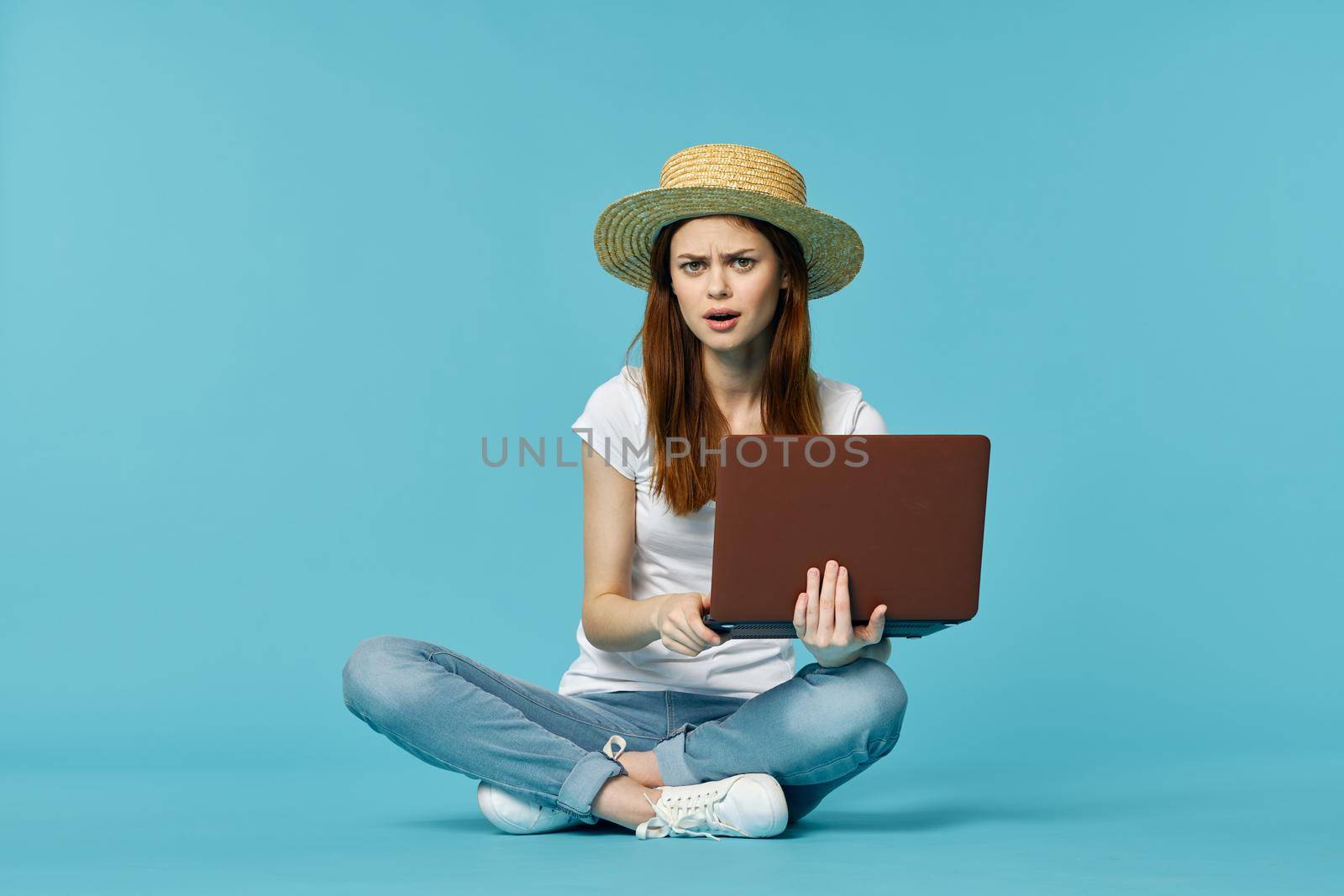 woman with laptop learning internet online education blue background. High quality photo