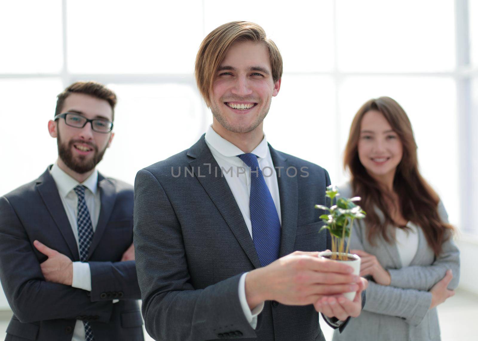 close up.a group of young people with a plant sprout by asdf