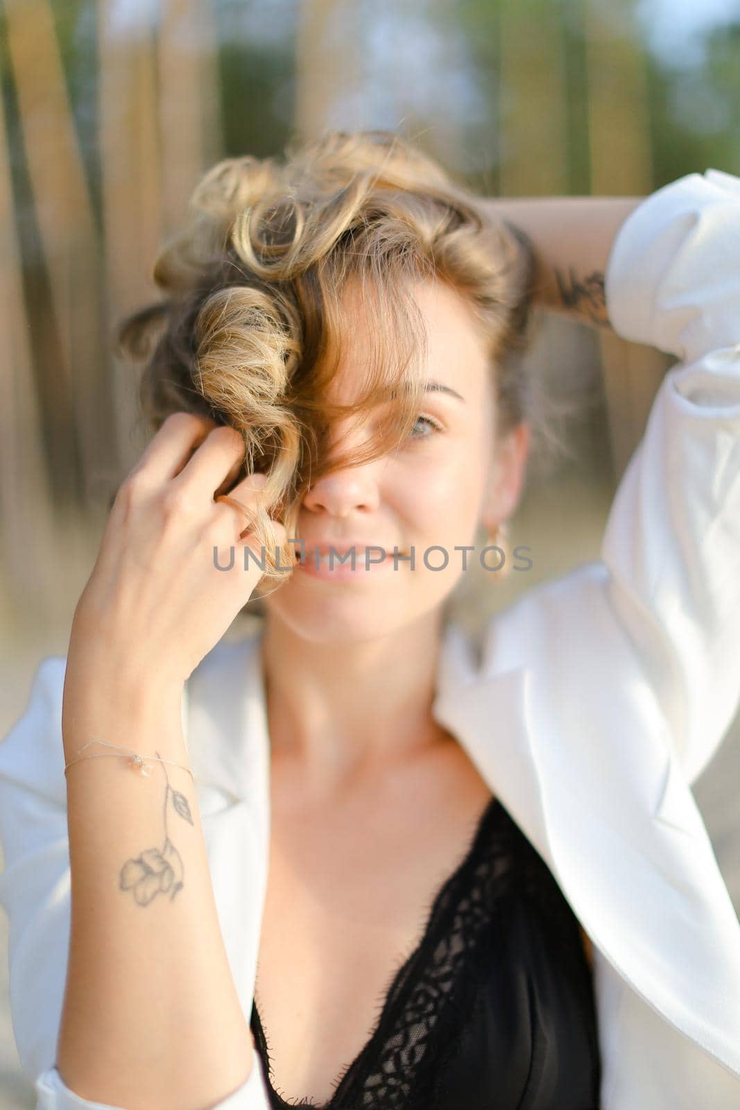 Portraint of young caucasian girl with little hand tattoo wearing white shirt and black bra. Concept of beauty.