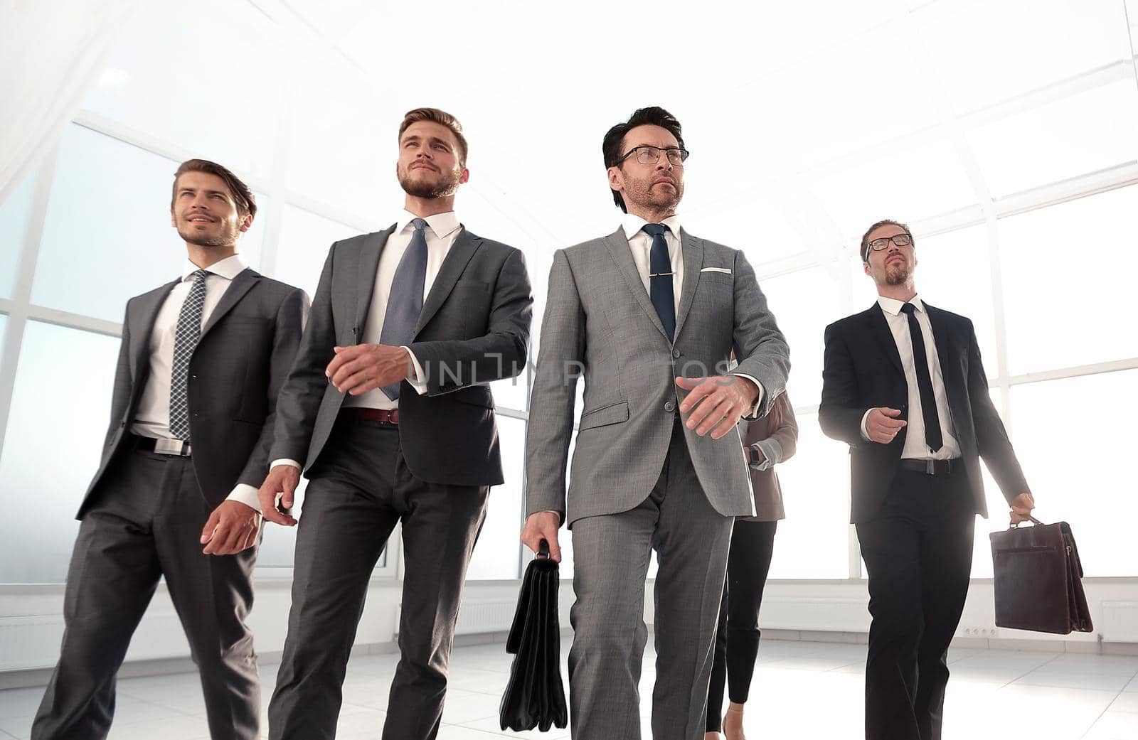 Confident business partners walking down in office building and talking