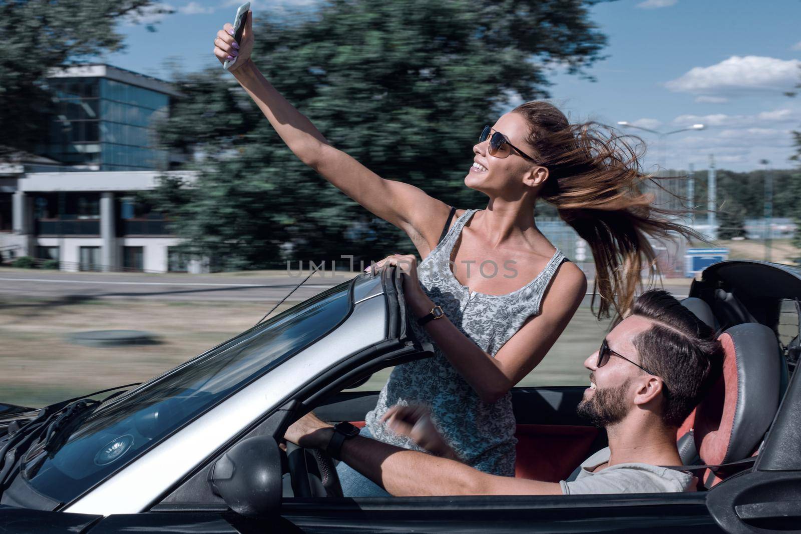 charming young couple taking selfie in car by asdf