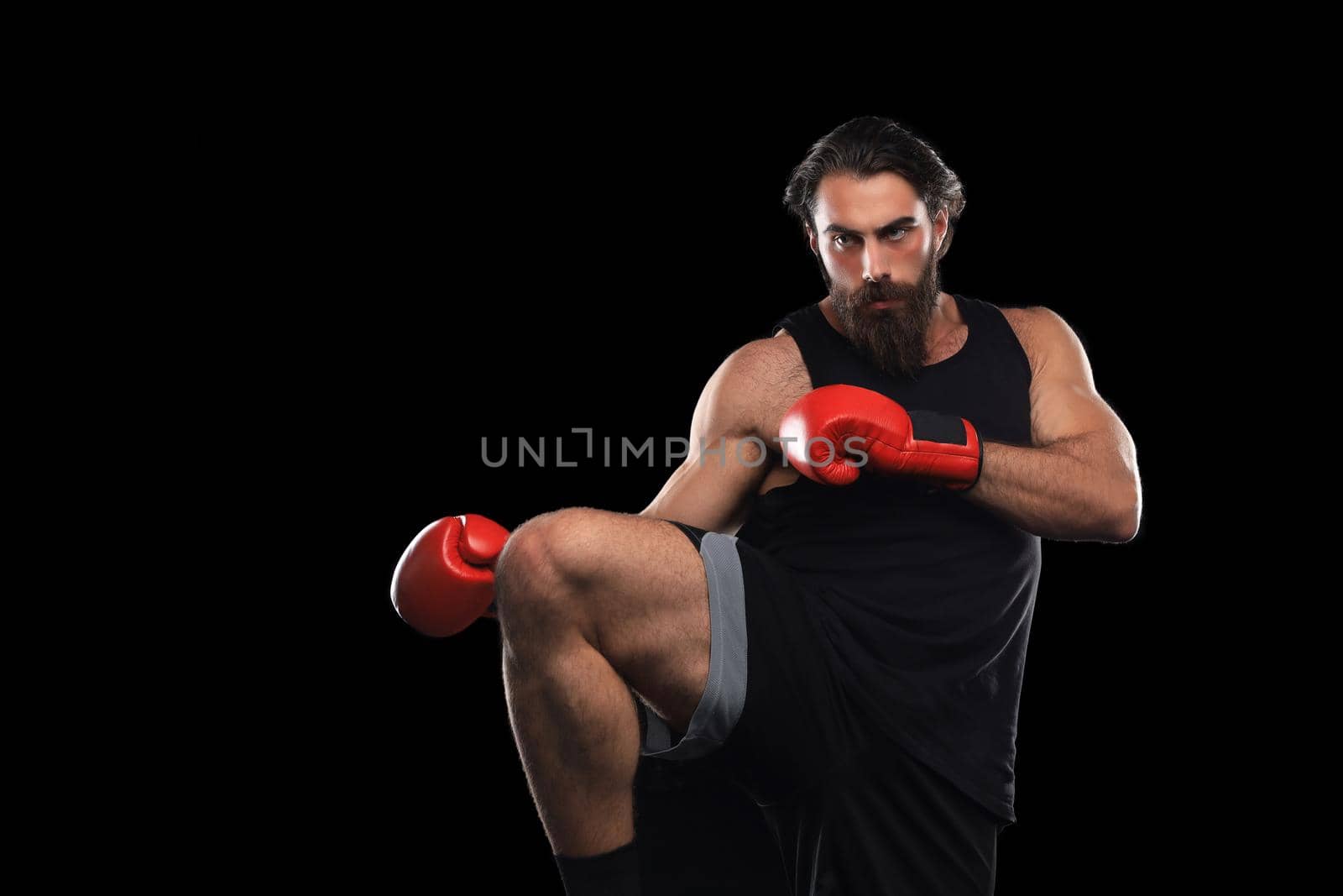 Kickboxer man fighting against black background. Sport concept