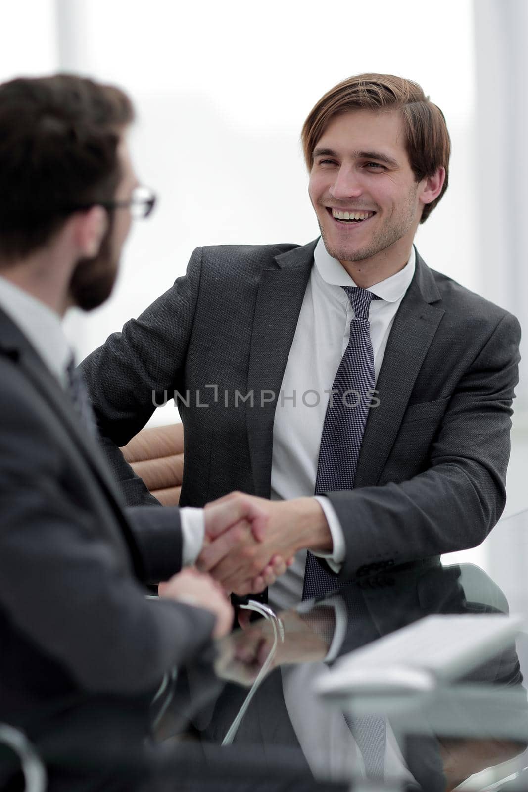 close up. handshake business partners sitting at the Desk .concept of partnership