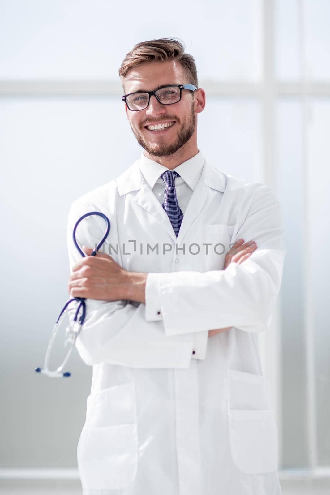 Close up portrait of a smiling middle aged doctor in lab coat with stethoscope