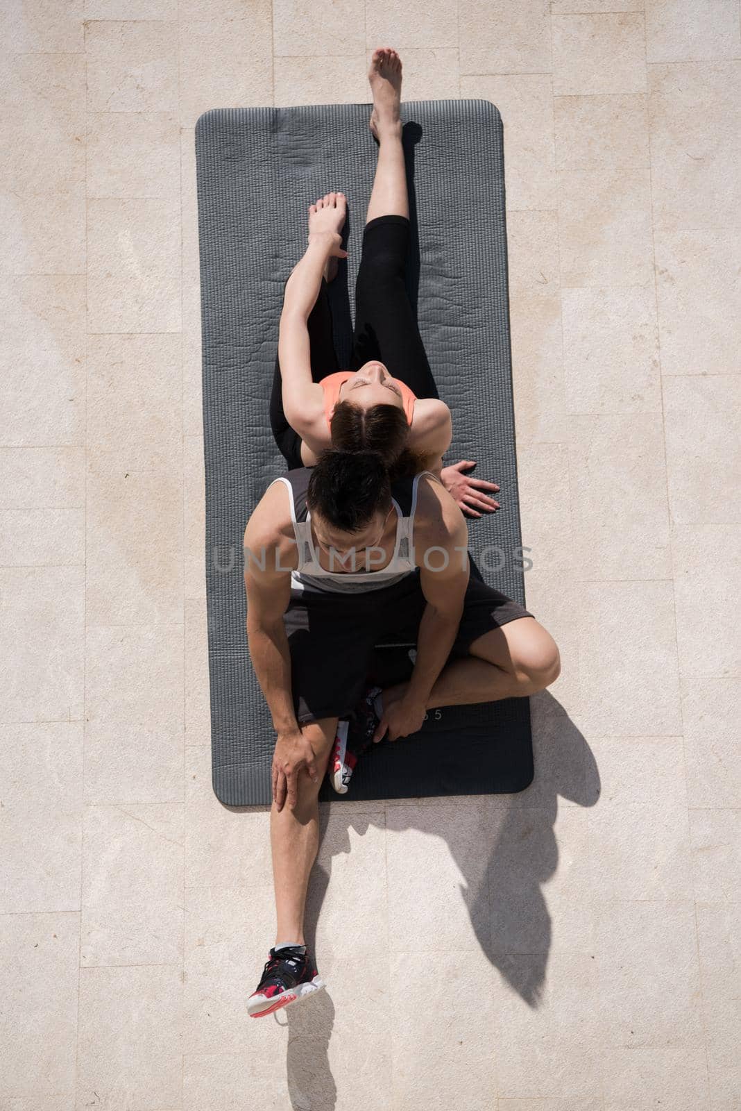 woman with personal trainer doing morning yoga exercises top view by dotshock