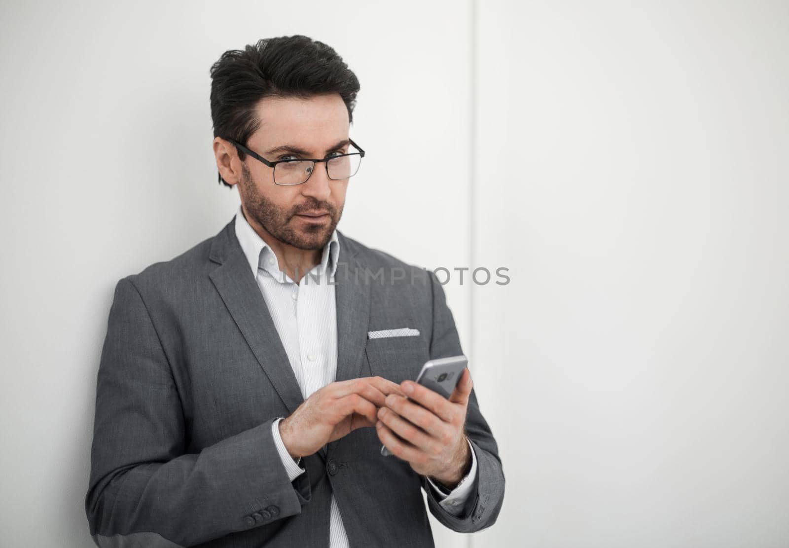 confident businessman typing SMS on your smartphone.photo with copy space