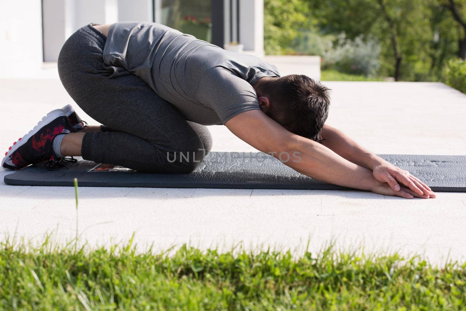 man doing morning yoga exercises by dotshock