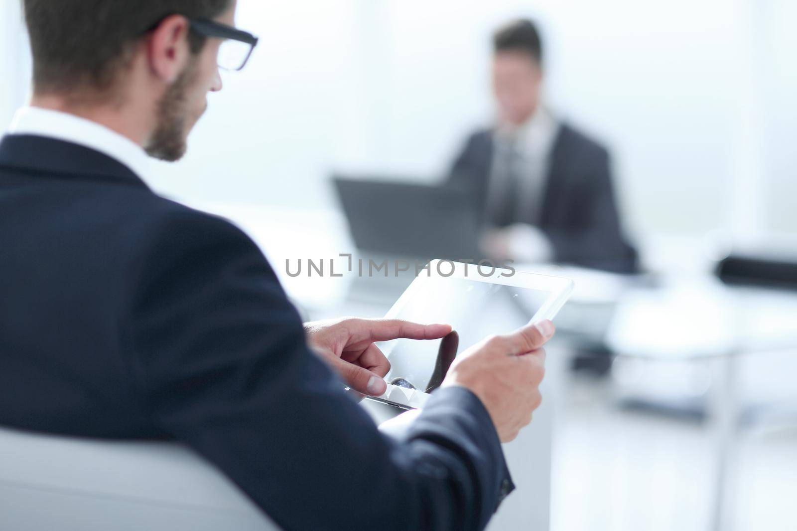young successful intelligent male in suit use digital tablet during work break