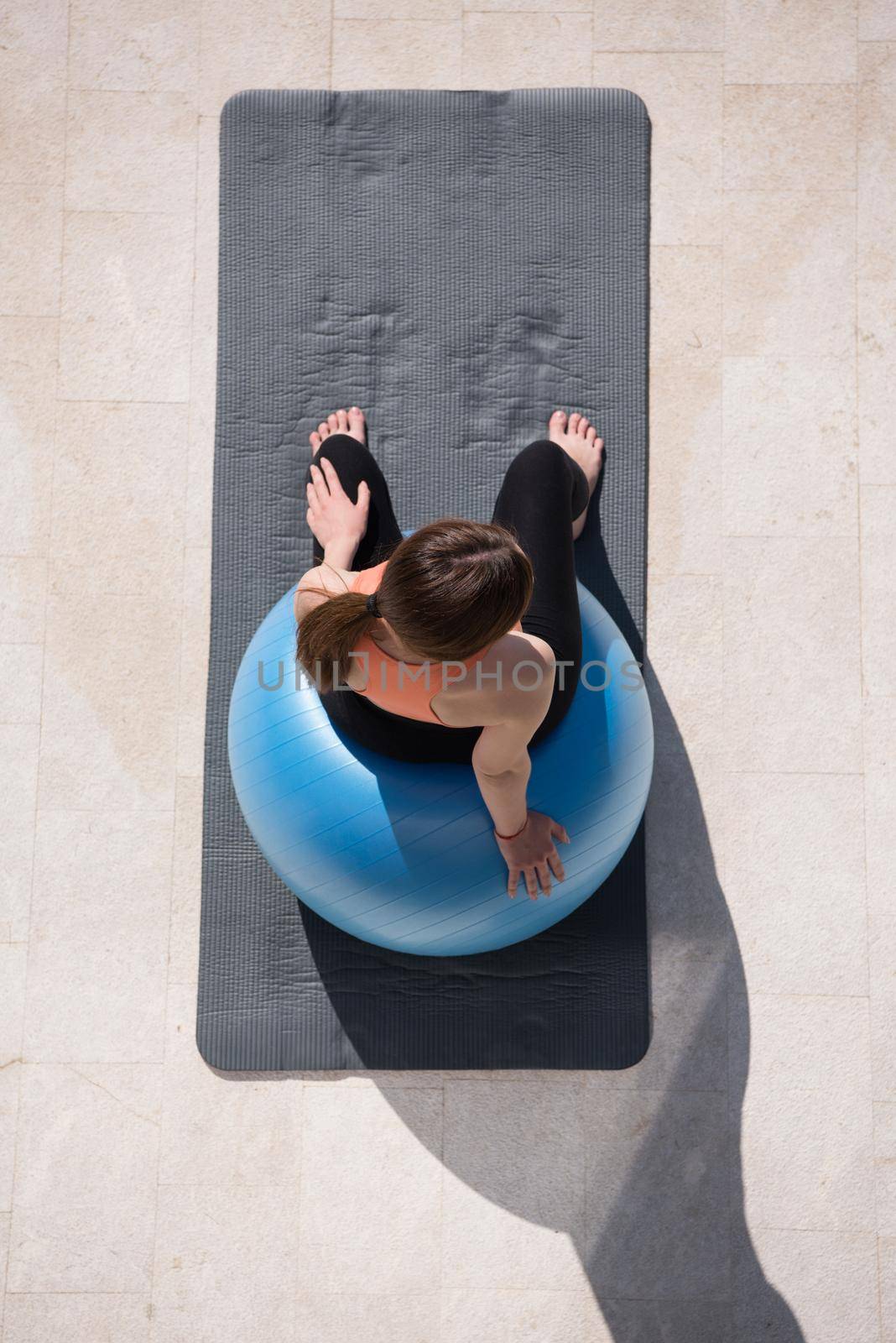 woman doing exercise with pilates ball top view by dotshock