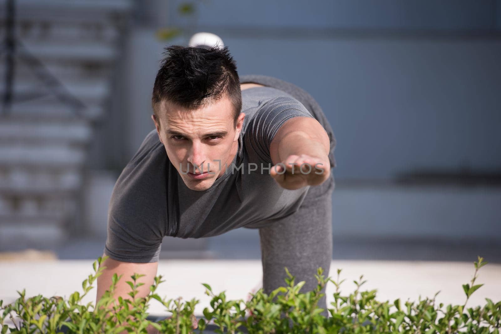 young handsome man doing morning yoga exercises in front of his luxury home villa