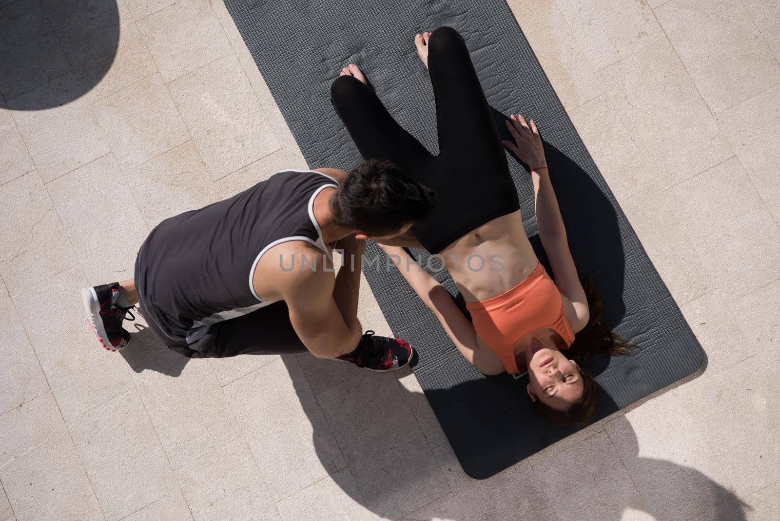 woman with personal trainer doing morning yoga exercises top view by dotshock