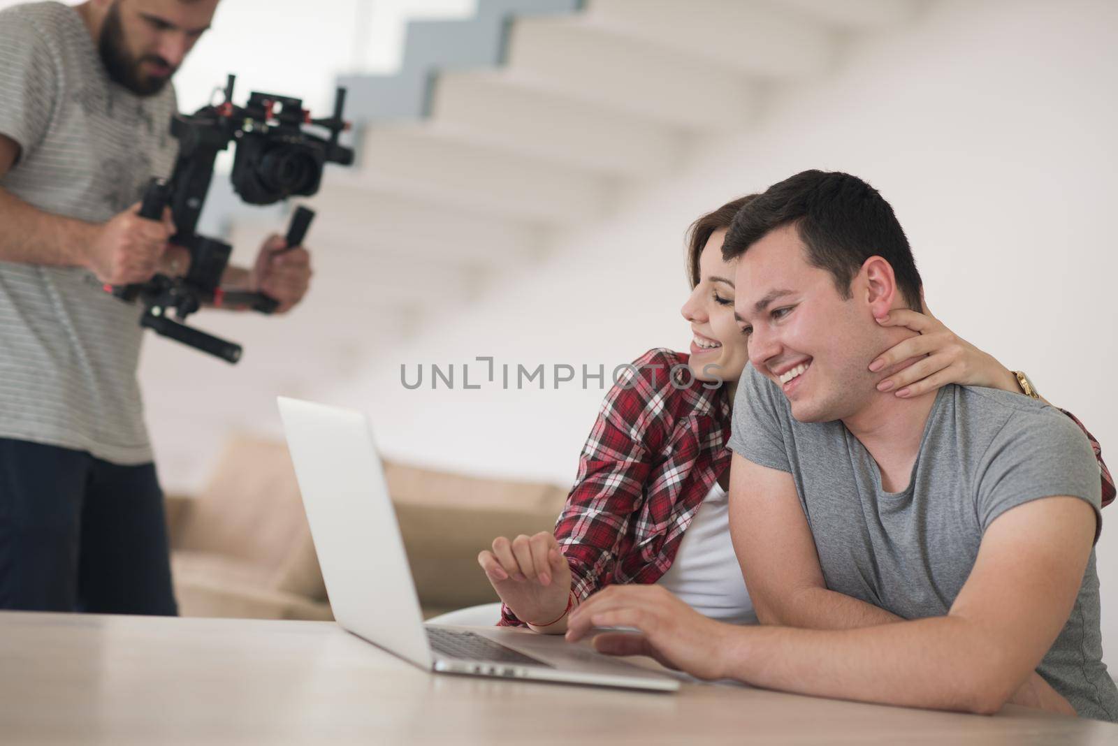 happy young couple buying online using laptop a computer and a credit card in their luxury home villa